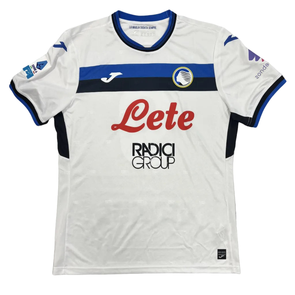 White sports jersey with blue and red accents on a gray surface