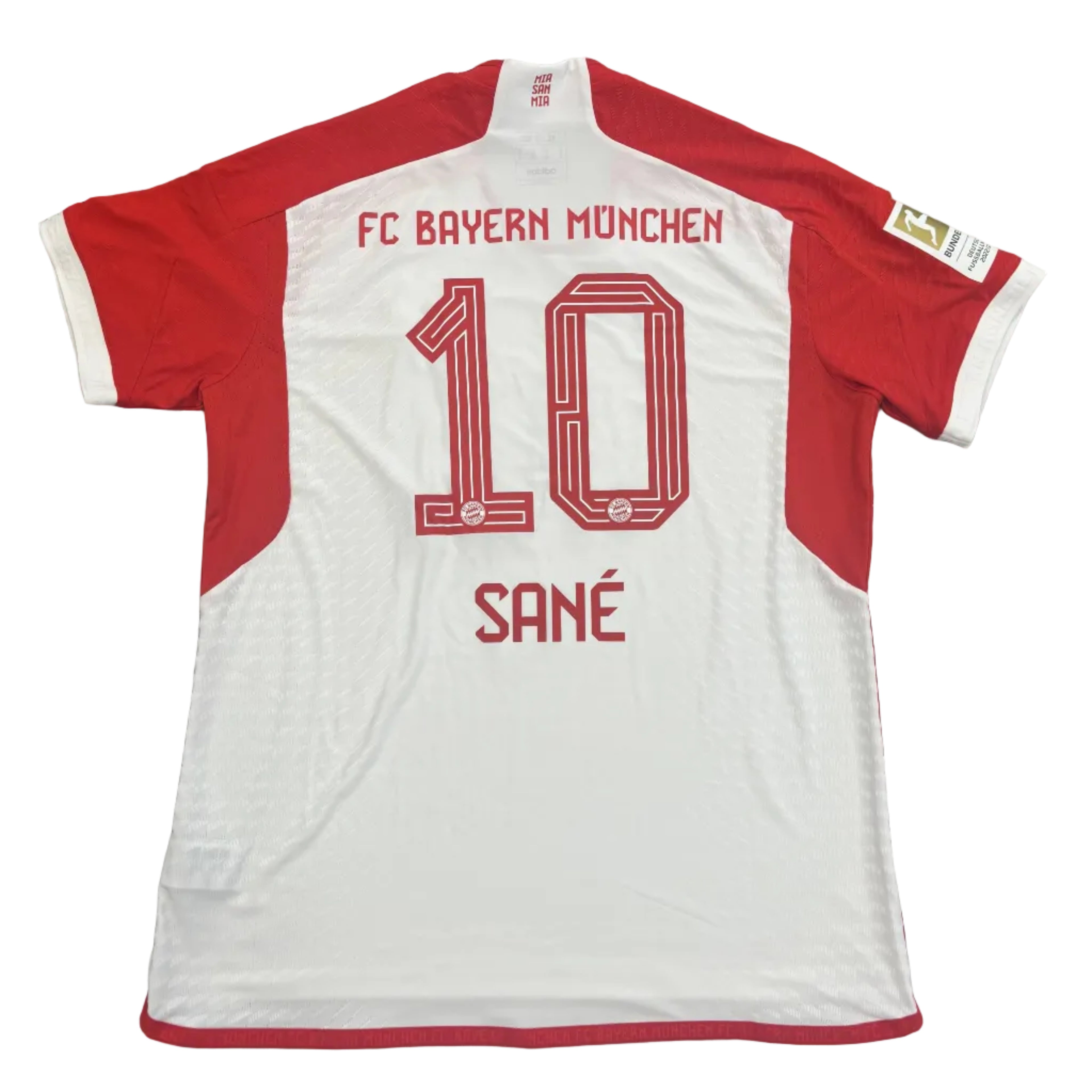 White and red sports jersey with 'FC Bayern Munich' and number '10' on a gray surface.