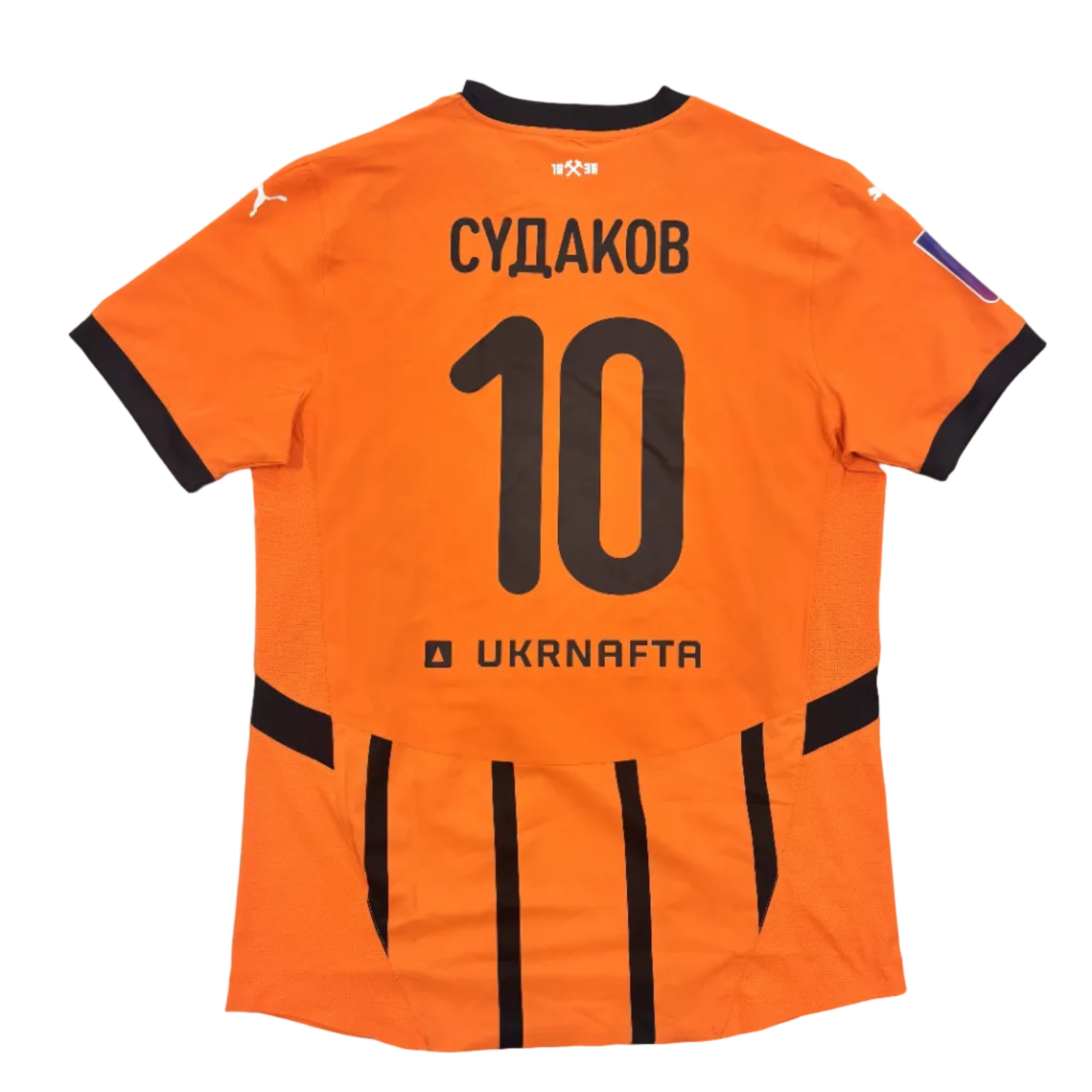 Orange sports jersey with black text and numbering on a round surface.
