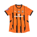 Orange sports jersey with black accents on a round white table.