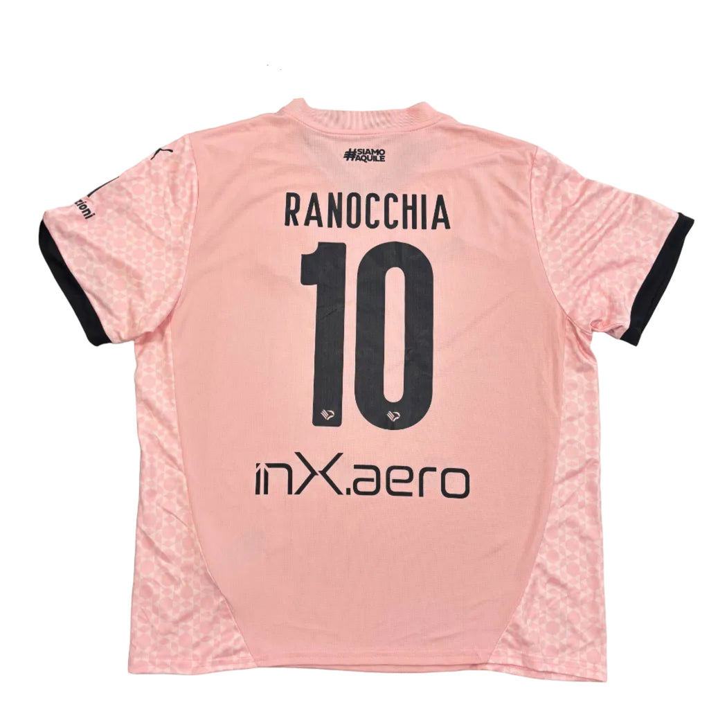 Pink sports jersey with 'RANOCCHIA 10' printed on it, displayed on a round gray surface.