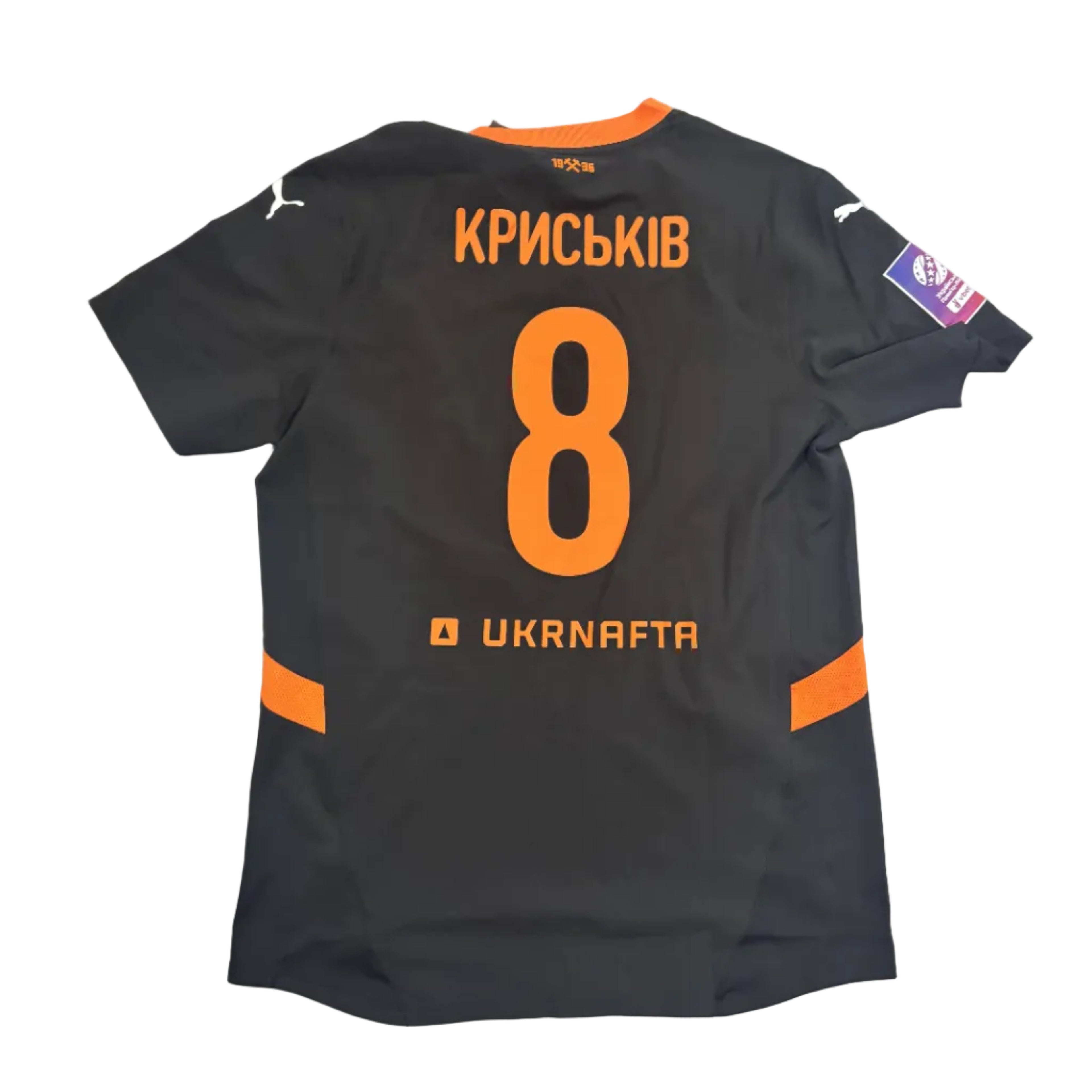 Black sports jersey with orange numbering and text on a white surface