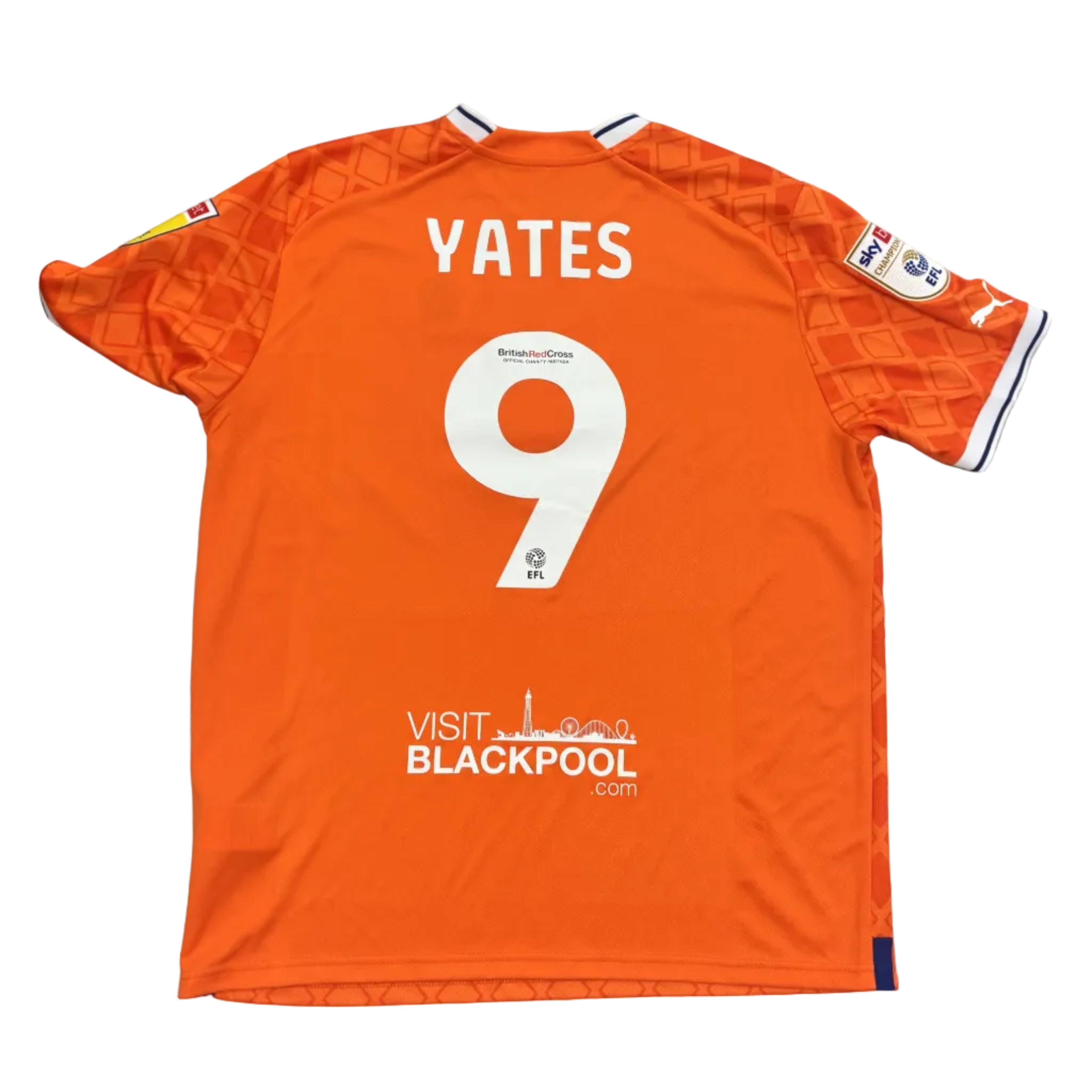Orange sports jersey with 'YATES 9' printed on it, placed on a round gray table.