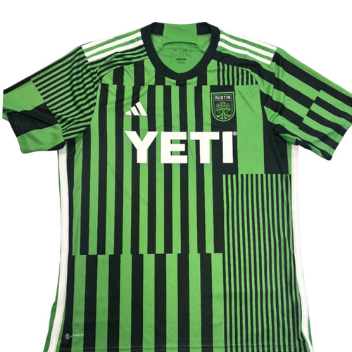 Green and black striped sports jersey with YETI logo on a round surface